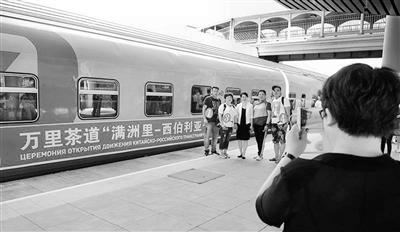 7月3日,万里茶道“满洲里—西伯利亚”中俄跨境旅游专列首发,乘客与列车合影。